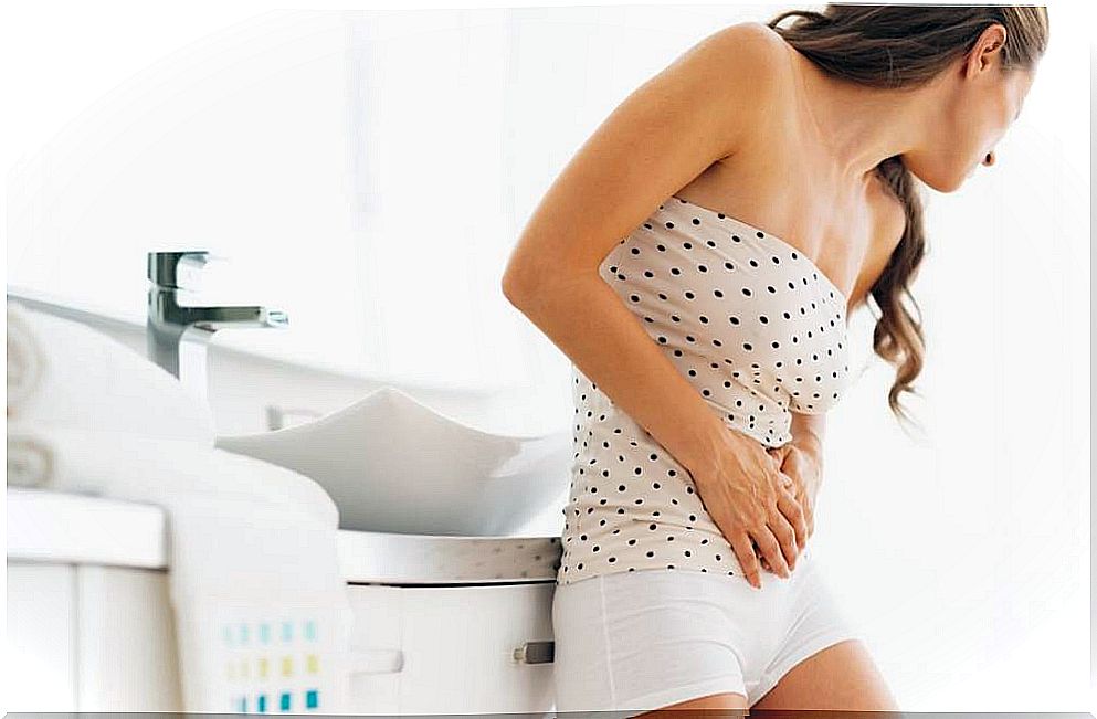 A woman with a bladder infection, an early warning sign of diabetes, is holding her abdomen.