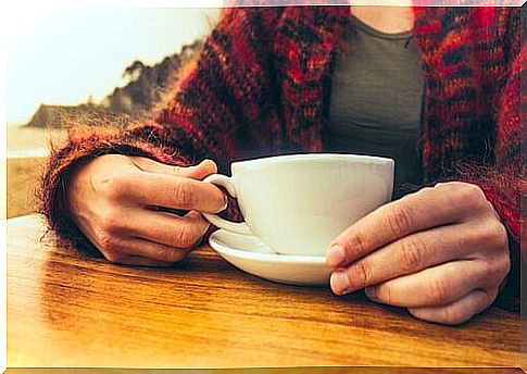 Hands hold coffee cup