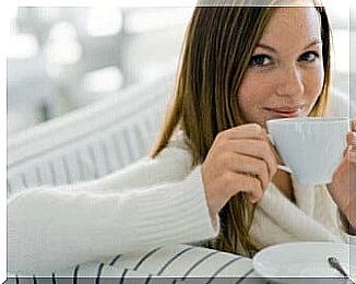 Woman drinks warm water from cup