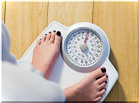 Woman stands on the scales and wants to lose weight with a sirtfood diet